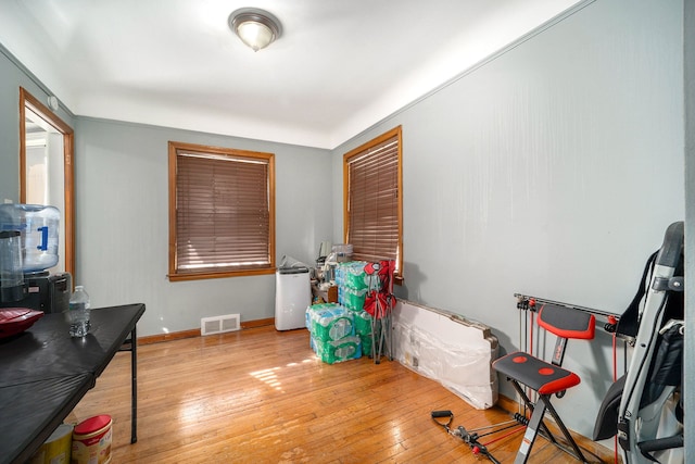 interior space with hardwood / wood-style floors, baseboards, and visible vents