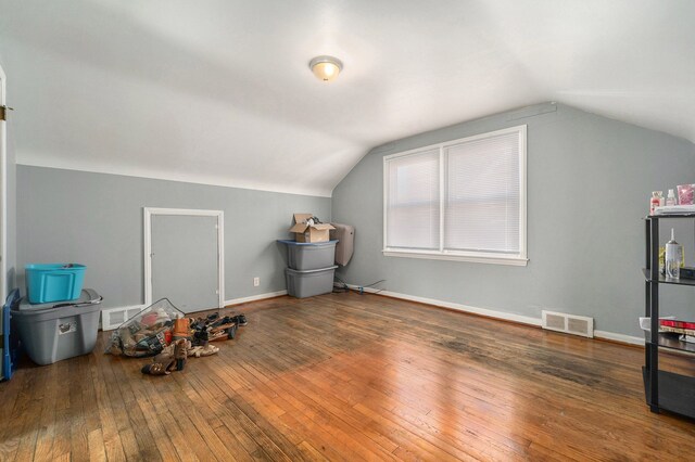 playroom with hardwood / wood-style floors, vaulted ceiling, baseboards, and visible vents