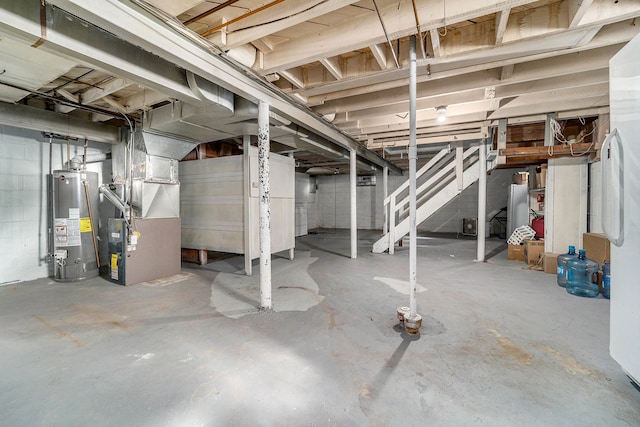 unfinished below grade area featuring stairs, heating unit, concrete block wall, and water heater