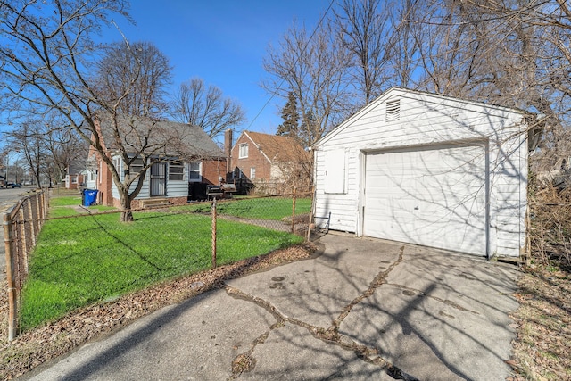 detached garage featuring aphalt driveway and fence