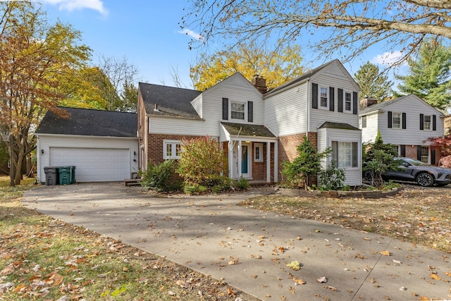 traditional-style house with a garage, driveway, brick siding, and a chimney