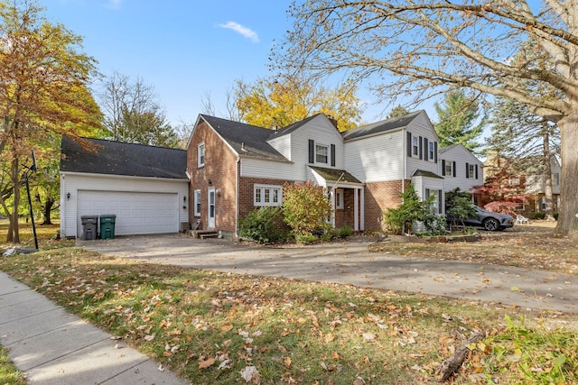 traditional-style house with concrete driveway, brick siding, and an attached garage