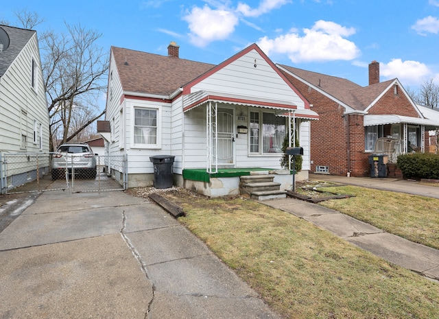 bungalow-style home with concrete driveway, a chimney, roof with shingles, a gate, and a front yard