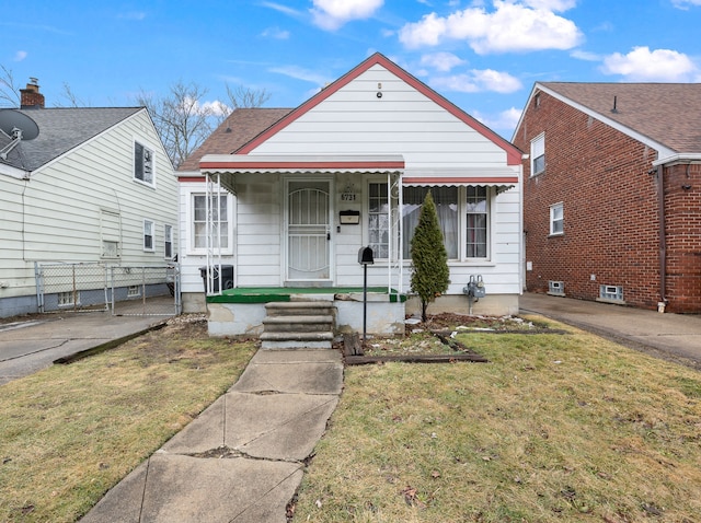 view of front of house featuring a front yard, fence, and a gate