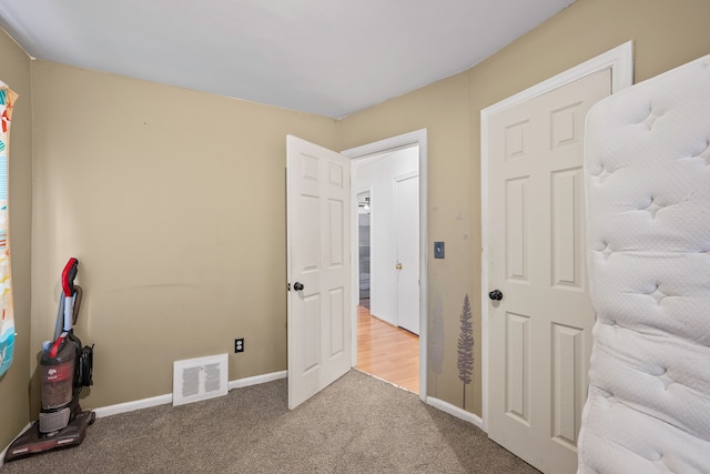 carpeted bedroom featuring visible vents and baseboards