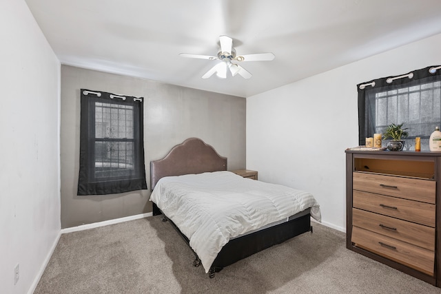 carpeted bedroom with ceiling fan and baseboards