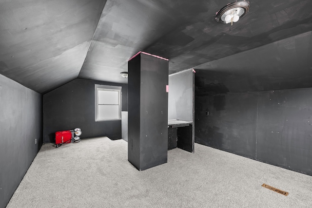 bonus room featuring visible vents, vaulted ceiling, and carpet flooring