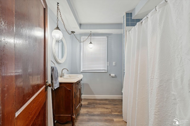 full bath featuring wood finished floors, vanity, and baseboards