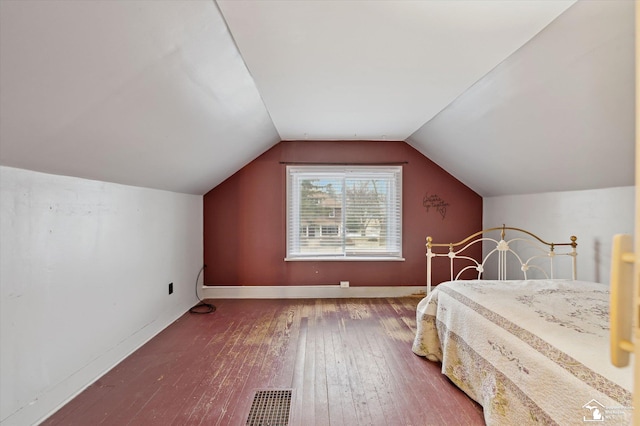 bedroom with lofted ceiling, wood-type flooring, visible vents, and baseboards