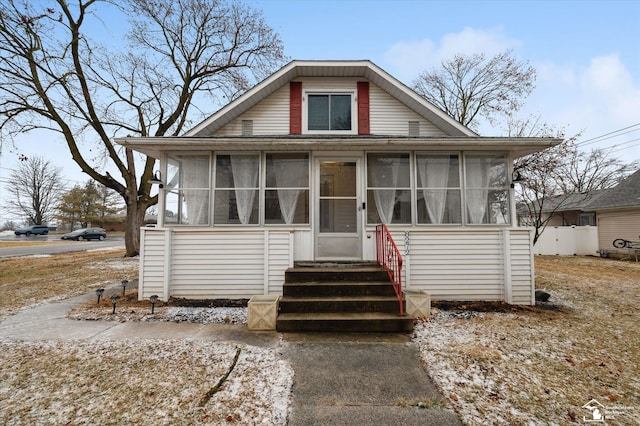 bungalow-style home with entry steps and a sunroom