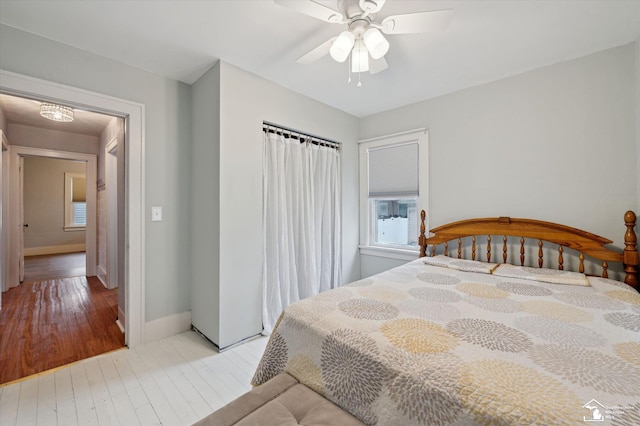 bedroom with ceiling fan, baseboards, and wood finished floors