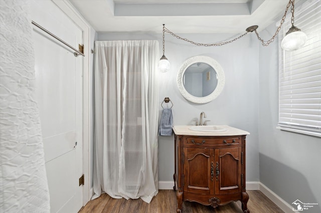 bathroom with baseboards, wood finished floors, and vanity