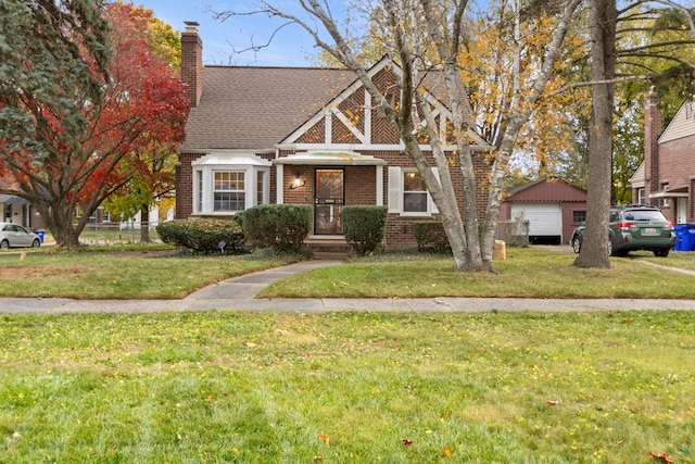 view of front of property with a chimney, a front lawn, and brick siding