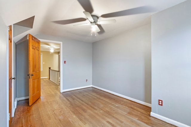 empty room with light wood finished floors, baseboards, and a ceiling fan