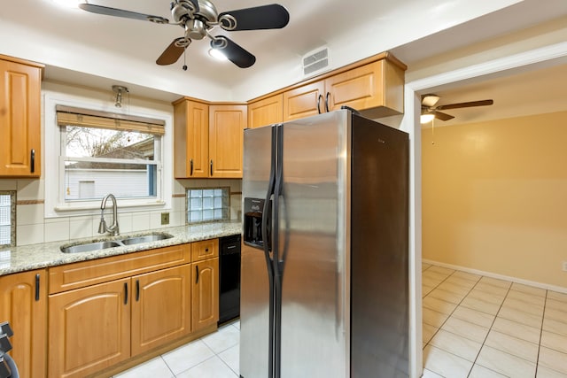 kitchen featuring light stone counters, backsplash, light tile patterned flooring, a sink, and stainless steel fridge with ice dispenser