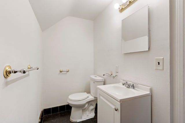 half bathroom with lofted ceiling, vanity, and toilet