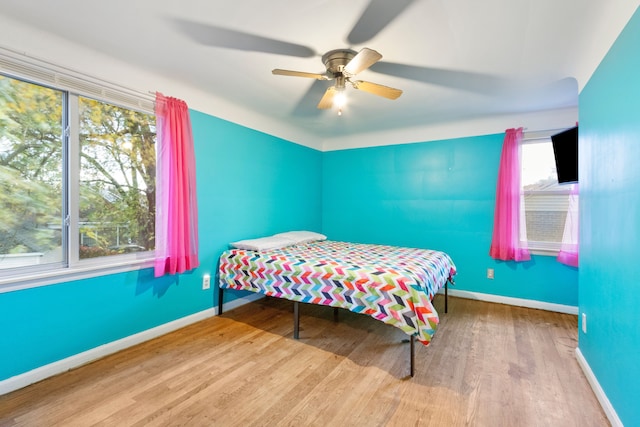 bedroom featuring ceiling fan, wood finished floors, and baseboards