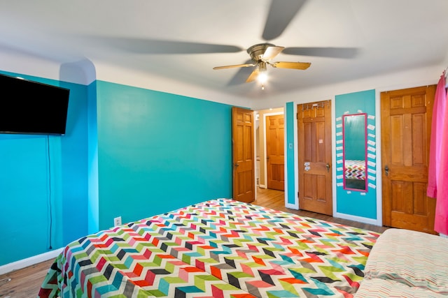 unfurnished bedroom featuring ceiling fan, wood finished floors, and baseboards