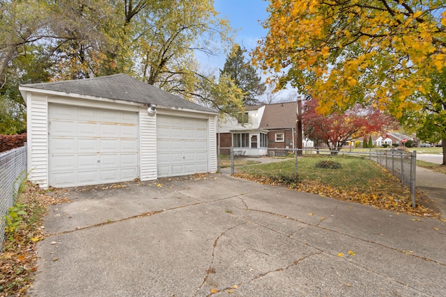 view of front of property with a garage, an outdoor structure, and fence private yard