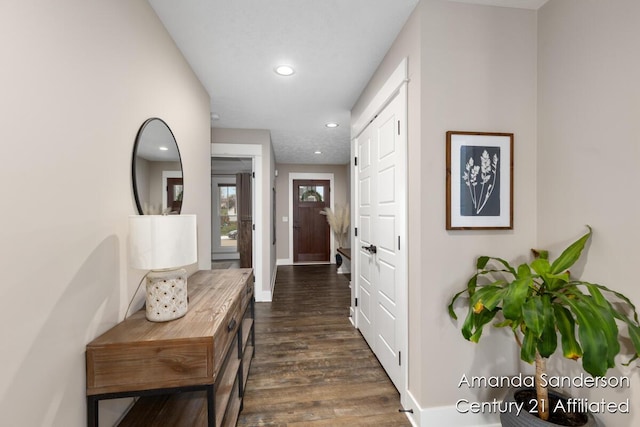 corridor featuring dark wood-type flooring, recessed lighting, and baseboards