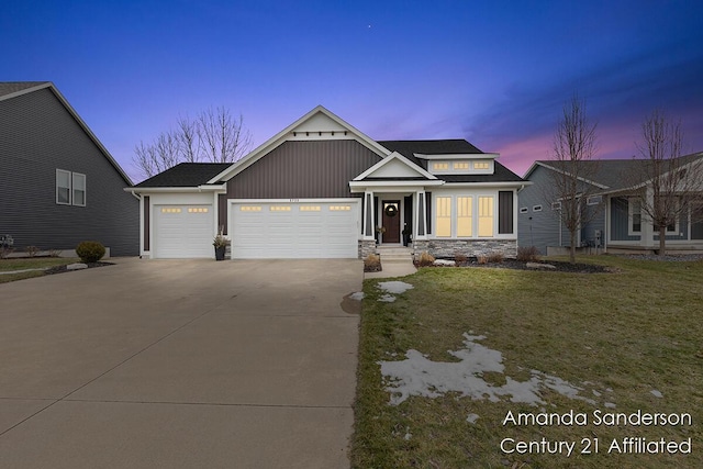 craftsman-style house featuring an attached garage, driveway, and a lawn