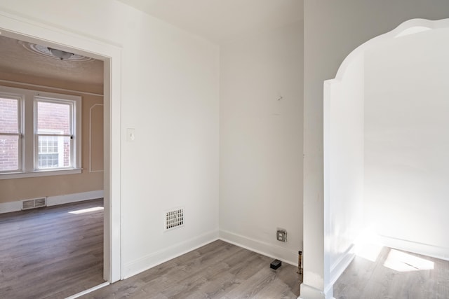 unfurnished room featuring visible vents, baseboards, and wood finished floors