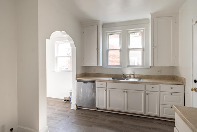 kitchen with a sink, stainless steel dishwasher, dark wood-style floors, and light countertops