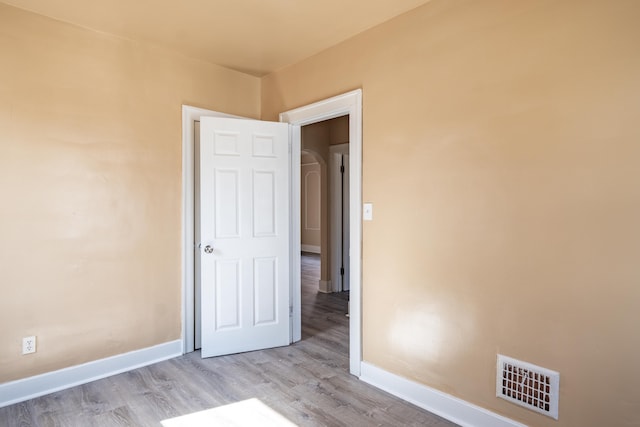 unfurnished bedroom featuring visible vents, baseboards, and wood finished floors