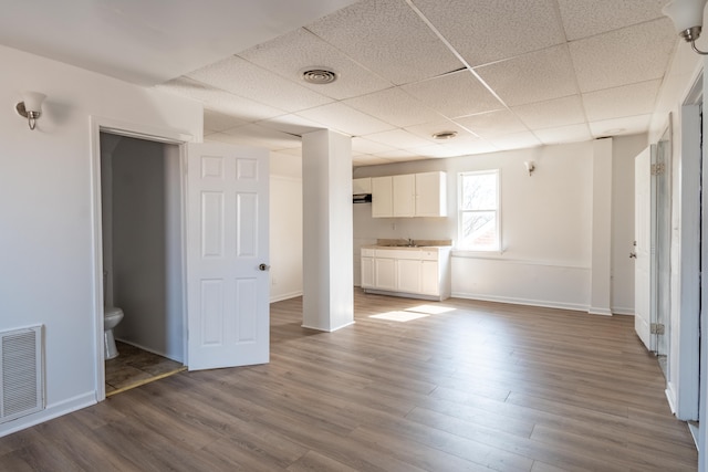 interior space with wood finished floors, visible vents, and a paneled ceiling