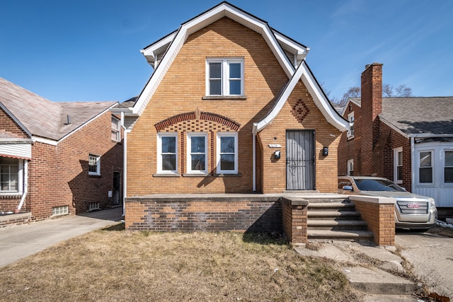 view of front facade featuring brick siding and a gambrel roof