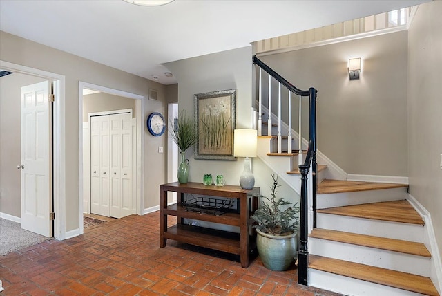 stairs featuring brick floor, visible vents, and baseboards