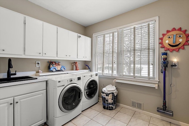 clothes washing area featuring washing machine and clothes dryer, light tile patterned floors, cabinet space, visible vents, and a sink