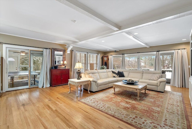 living room with beam ceiling, coffered ceiling, light wood-style flooring, and a healthy amount of sunlight