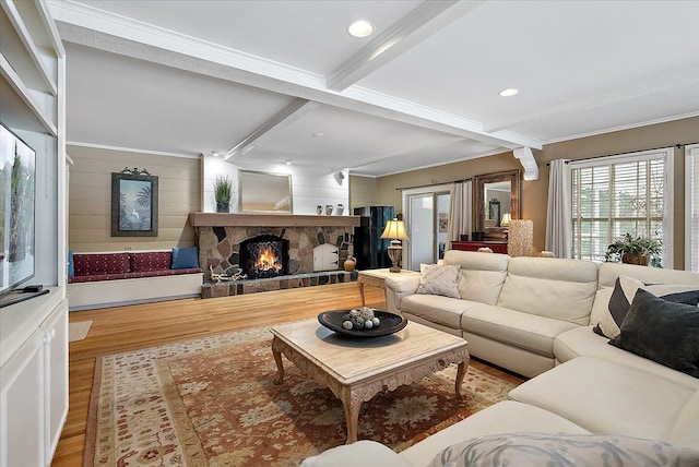 living area featuring a stone fireplace, wood finished floors, beam ceiling, and recessed lighting