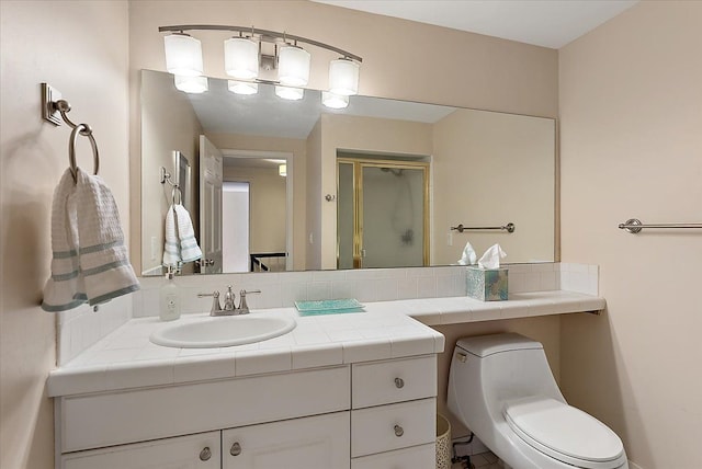 bathroom featuring toilet, a stall shower, and vanity