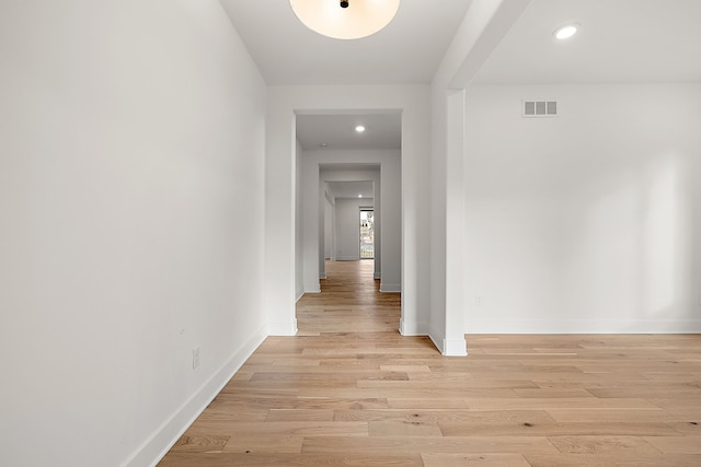 corridor featuring light wood finished floors, baseboards, visible vents, and recessed lighting