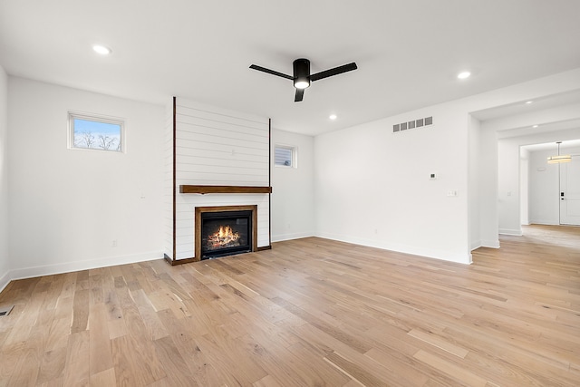 unfurnished living room featuring light wood finished floors, a large fireplace, visible vents, ceiling fan, and recessed lighting