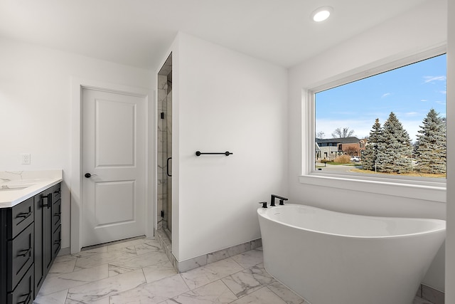 bathroom with a stall shower, marble finish floor, a freestanding tub, and vanity