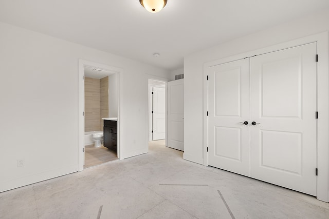 unfurnished bedroom with a closet, connected bathroom, and visible vents