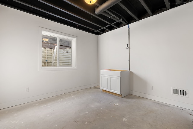 unfurnished room with concrete floors, visible vents, and baseboards