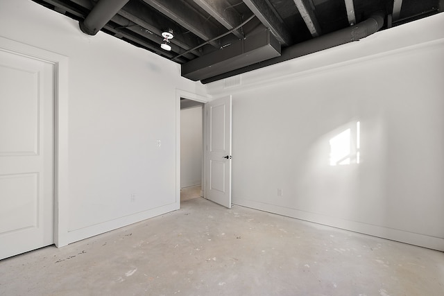 empty room with visible vents, concrete floors, and baseboards