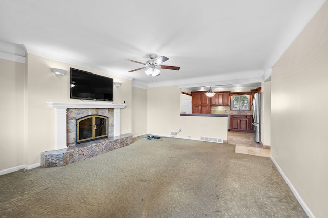 unfurnished living room featuring ornamental molding, baseboards, visible vents, and a premium fireplace