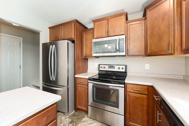 kitchen with appliances with stainless steel finishes, brown cabinetry, and light countertops