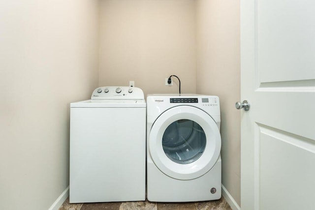 washroom with laundry area, independent washer and dryer, and baseboards