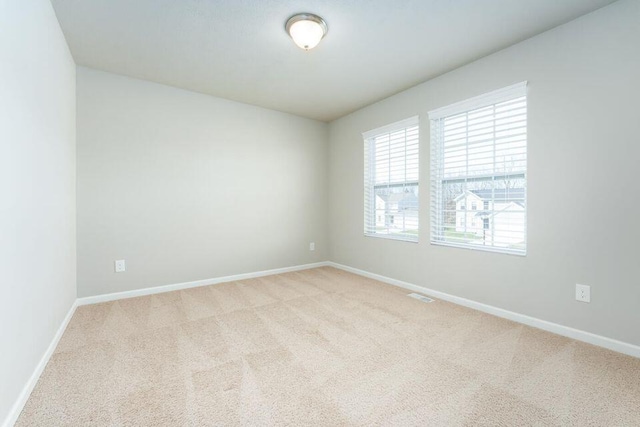 carpeted empty room with baseboards