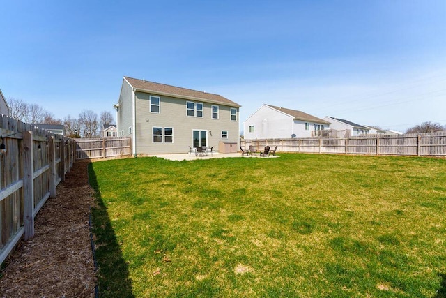 back of house featuring a fenced backyard, a patio, and a lawn