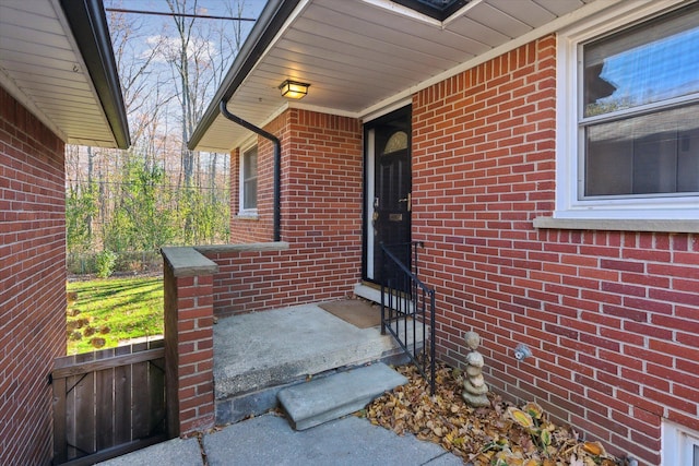 doorway to property with fence and brick siding