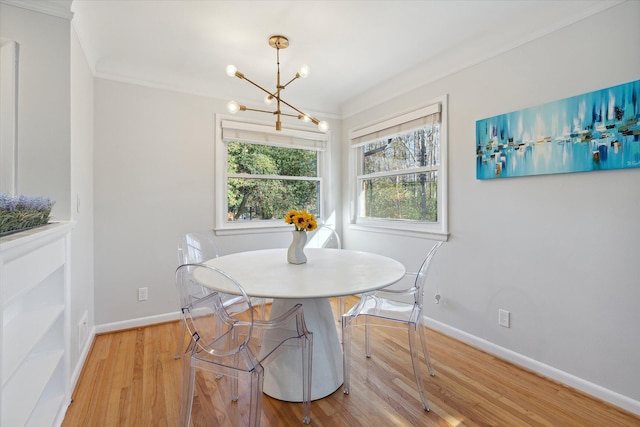 dining space featuring baseboards, crown molding, a chandelier, and light wood-style floors