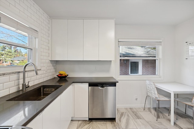 kitchen with tasteful backsplash, white cabinetry, dishwasher, and a sink