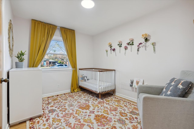 bedroom with a crib and baseboards